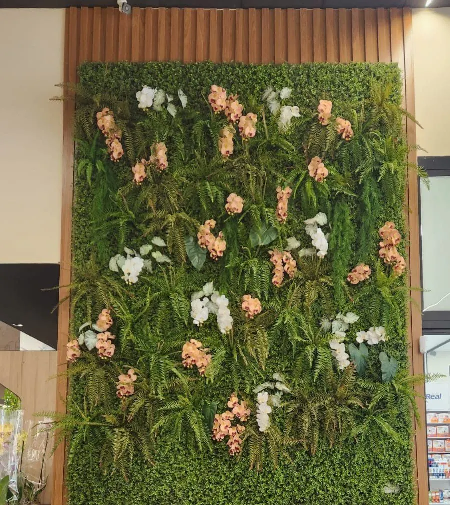 Jardim vertical com orquídeas brancas e salmão na entrada do Real Supermercados